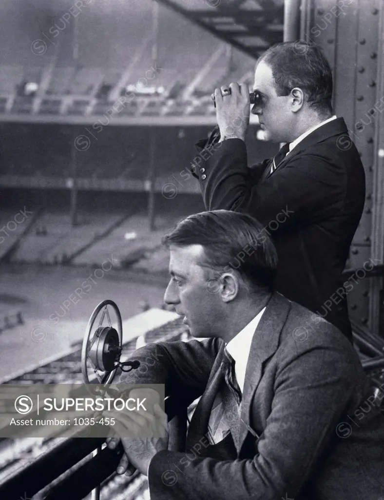 Side profile of two commentators in a stadium