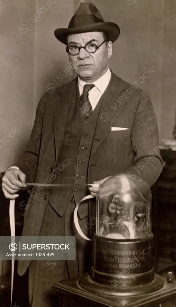 Portrait of a businessman holding ticker tape, 1923
