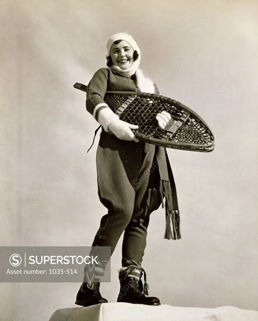 Low angle view of a young woman holding a snowshoe