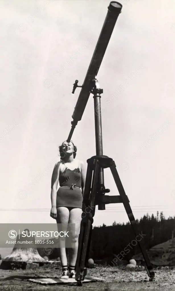 Young woman looking through a telescope