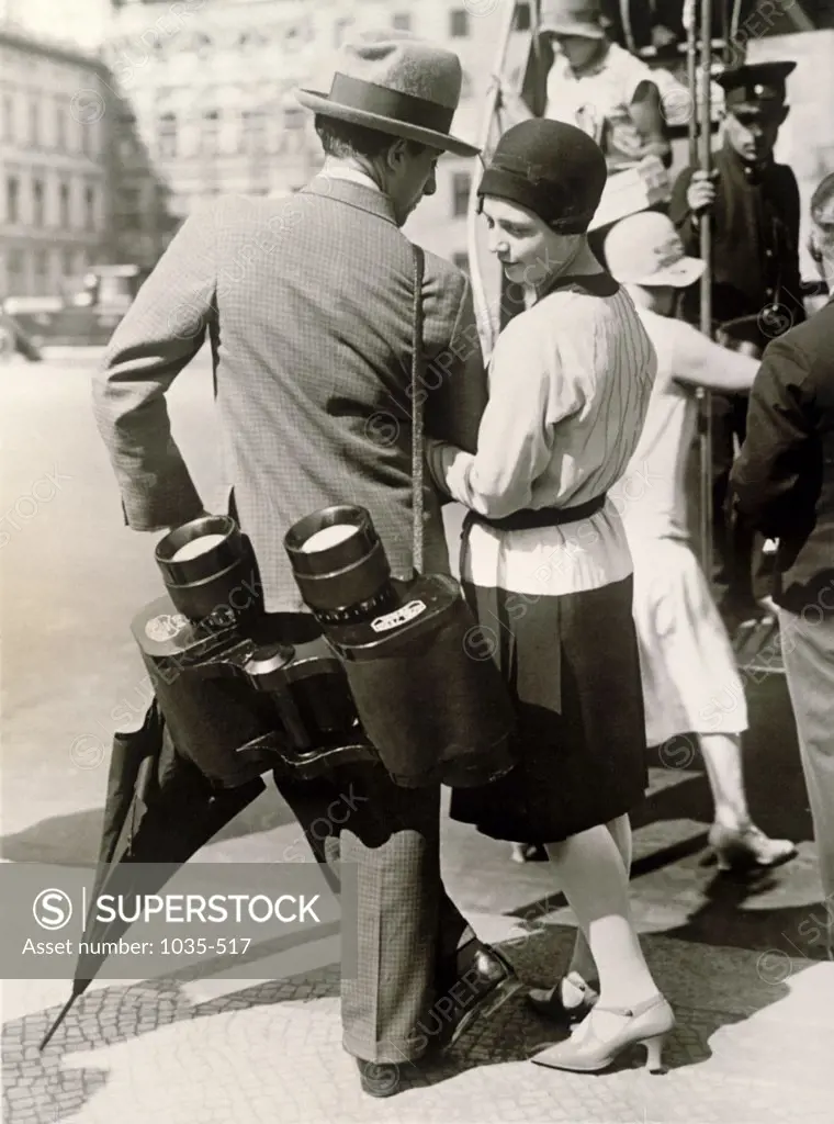 Rear view of a young couple standing with binoculars