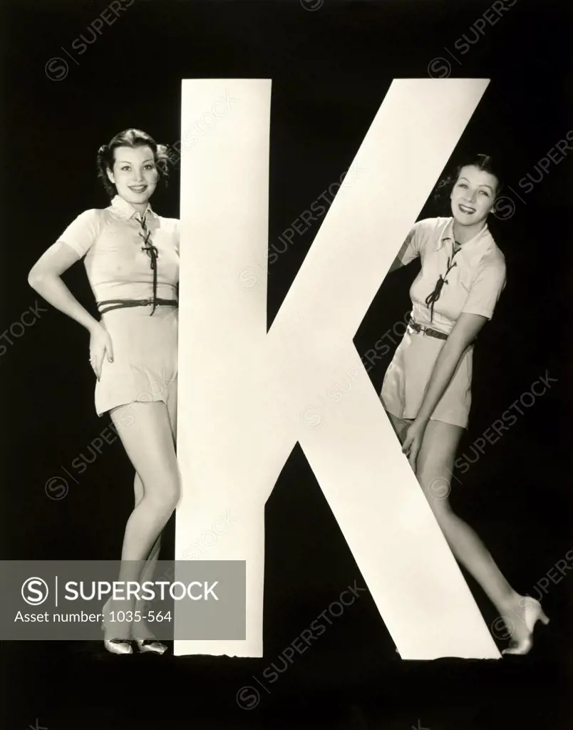 Portrait of two young women posing with the letter K