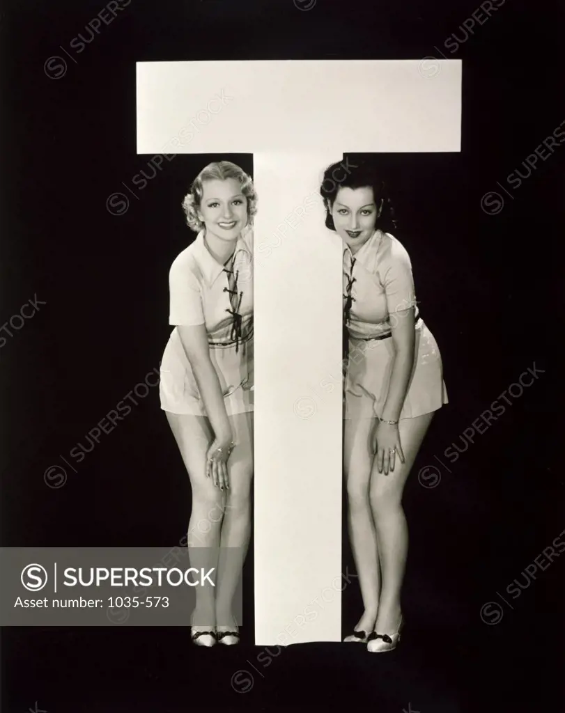 Portrait of two young women posing with the letter T