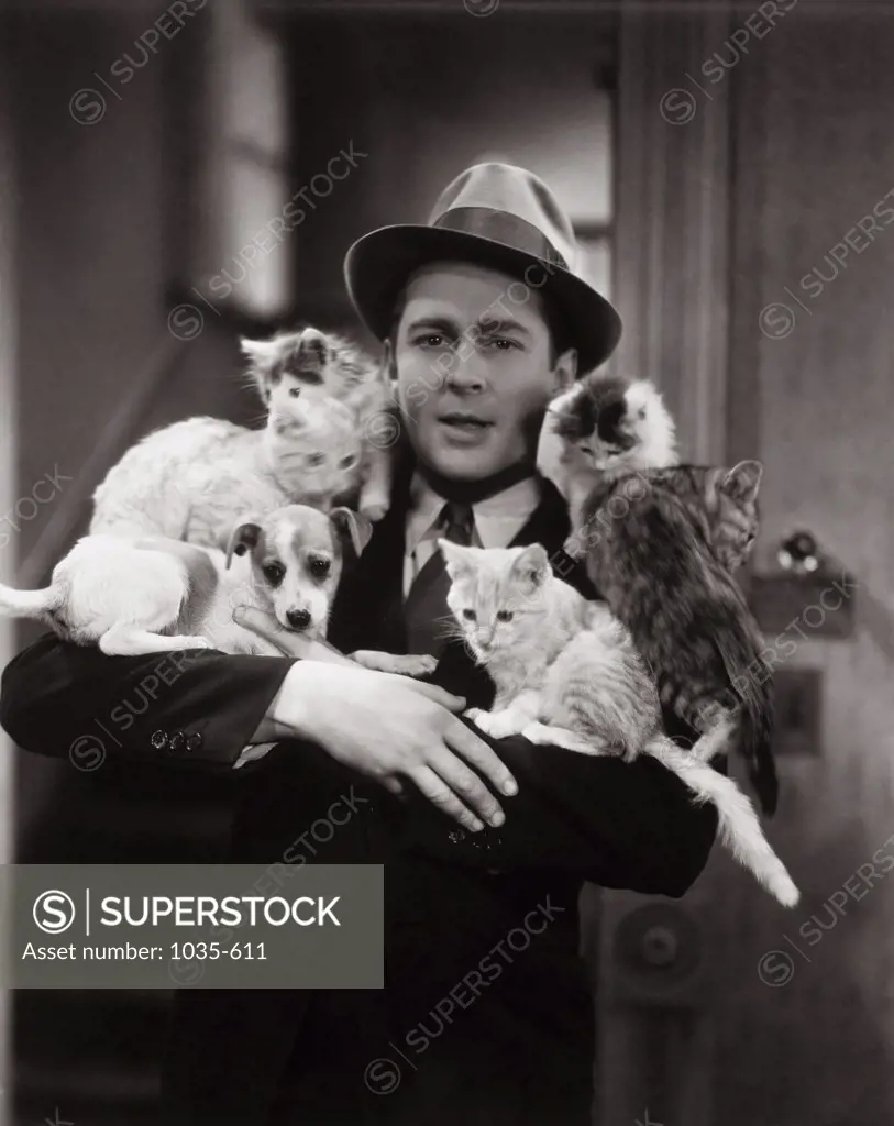 Portrait of a young man carrying a dog and cats