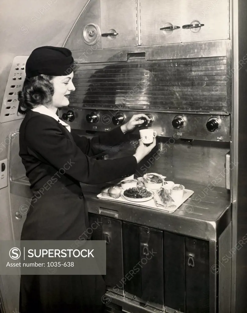 Side profile of an airplane stewardess preparing meals in an airplane