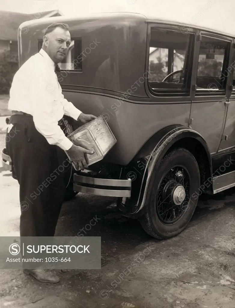 Portrait of a mature man refueling a vintage car