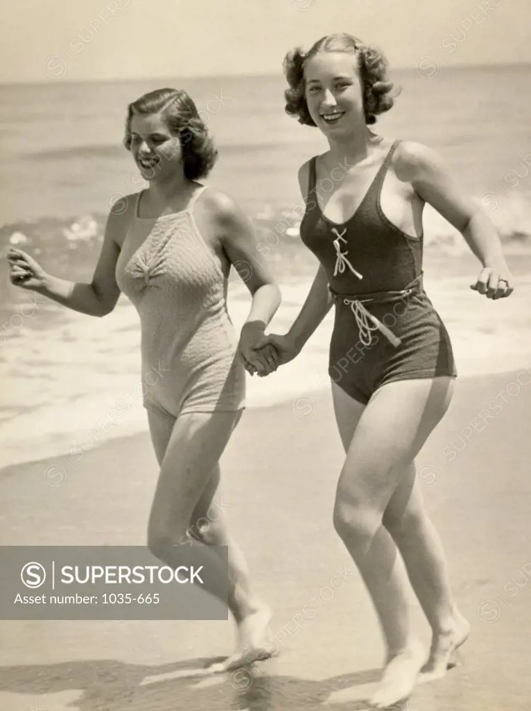Two young women running on the beach
