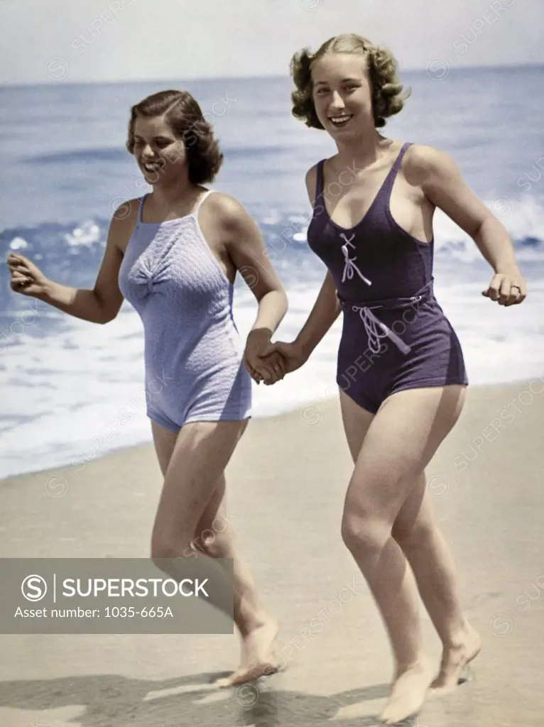 Two young women running on the beach