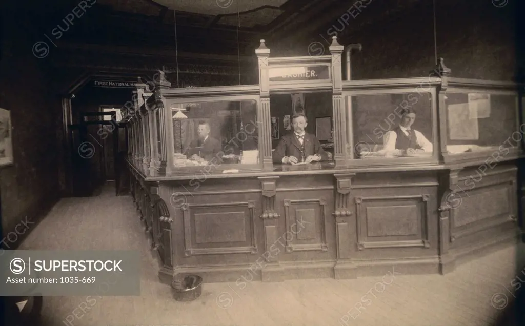 Bank tellers standing behind a bank counter