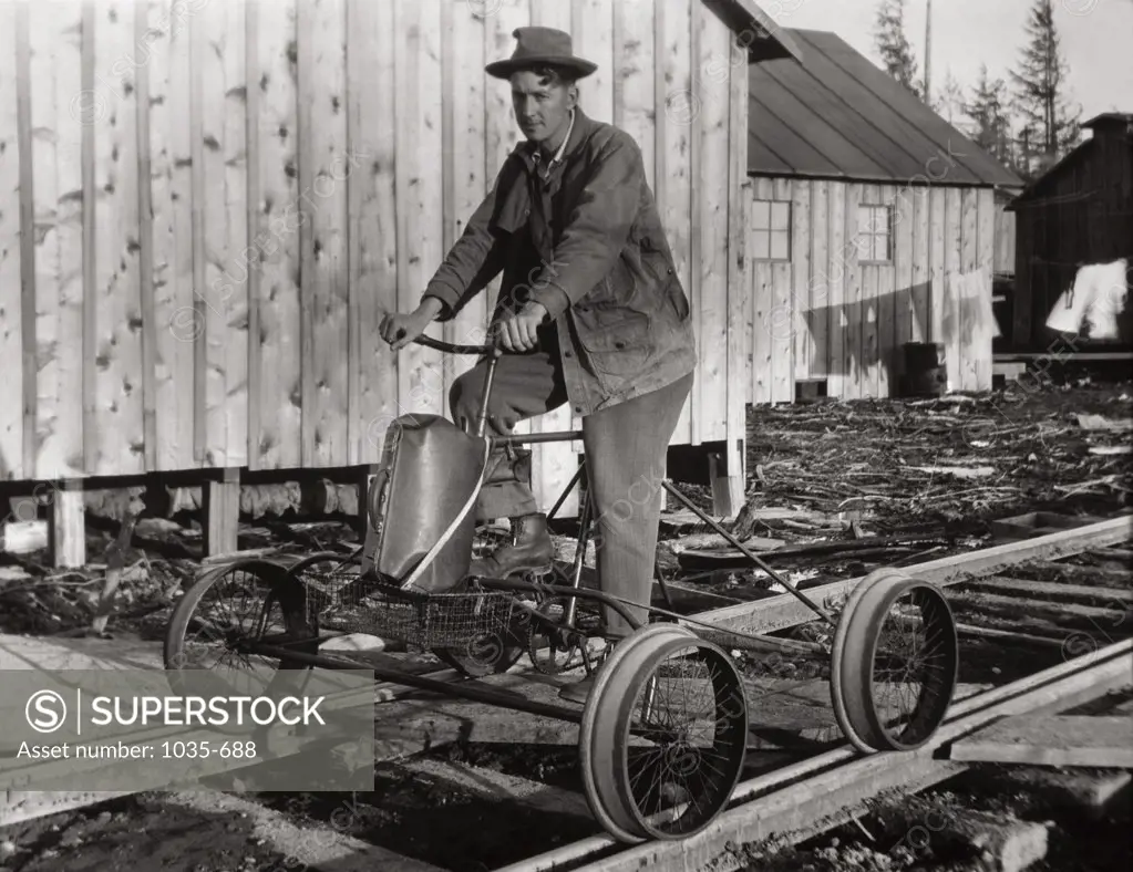 Young man driving a cart on a railroad track