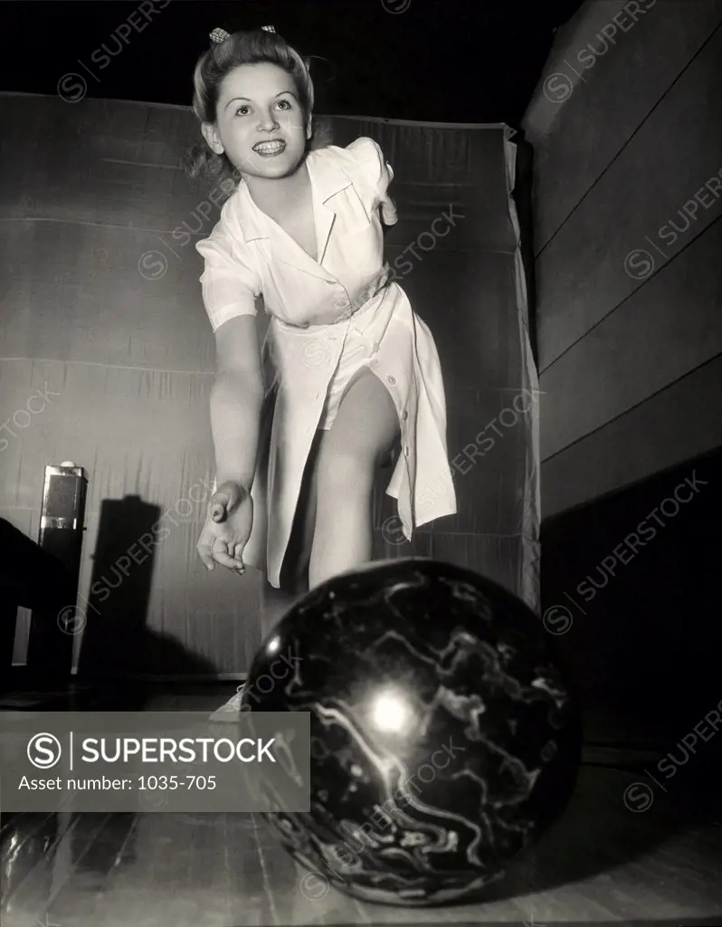 Low angle view of a young woman bowling