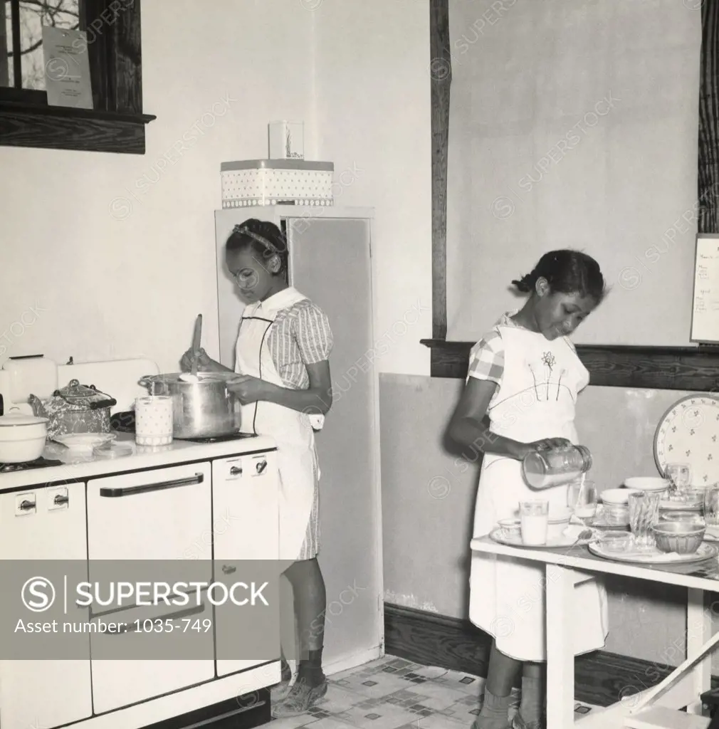 Two girls preparing food in the kitchen