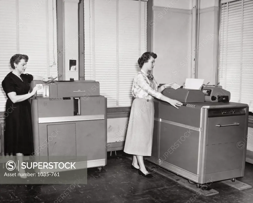 Two businesswomen working on computers in an office, IBM Accounting System