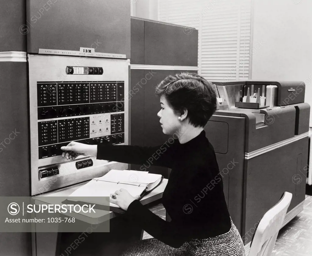 Side profile of a businesswoman operating a control panel, IBM 650 Data Processing System