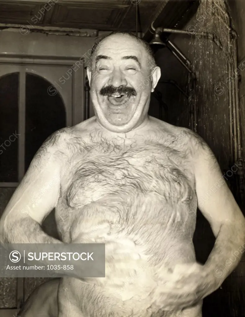 Close-up of a mature man taking a shower, 1938