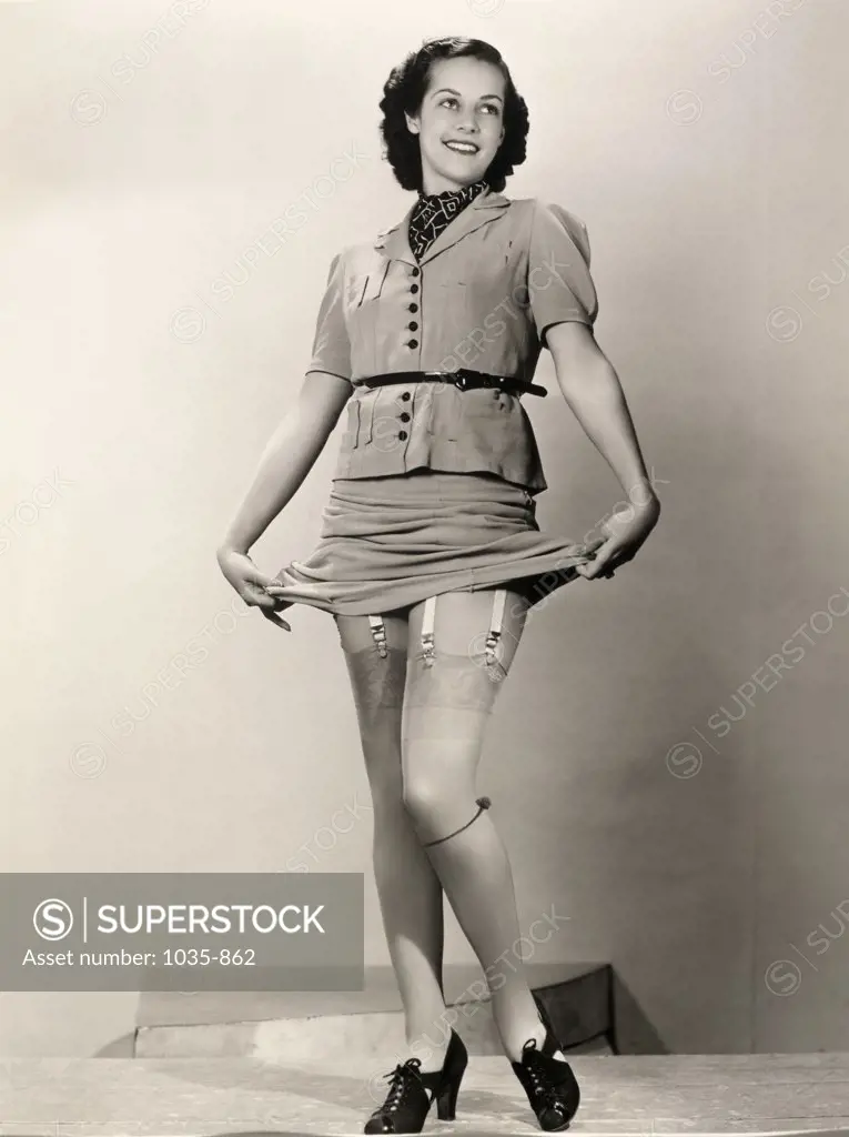 Young woman holding up her dress showing her stockings