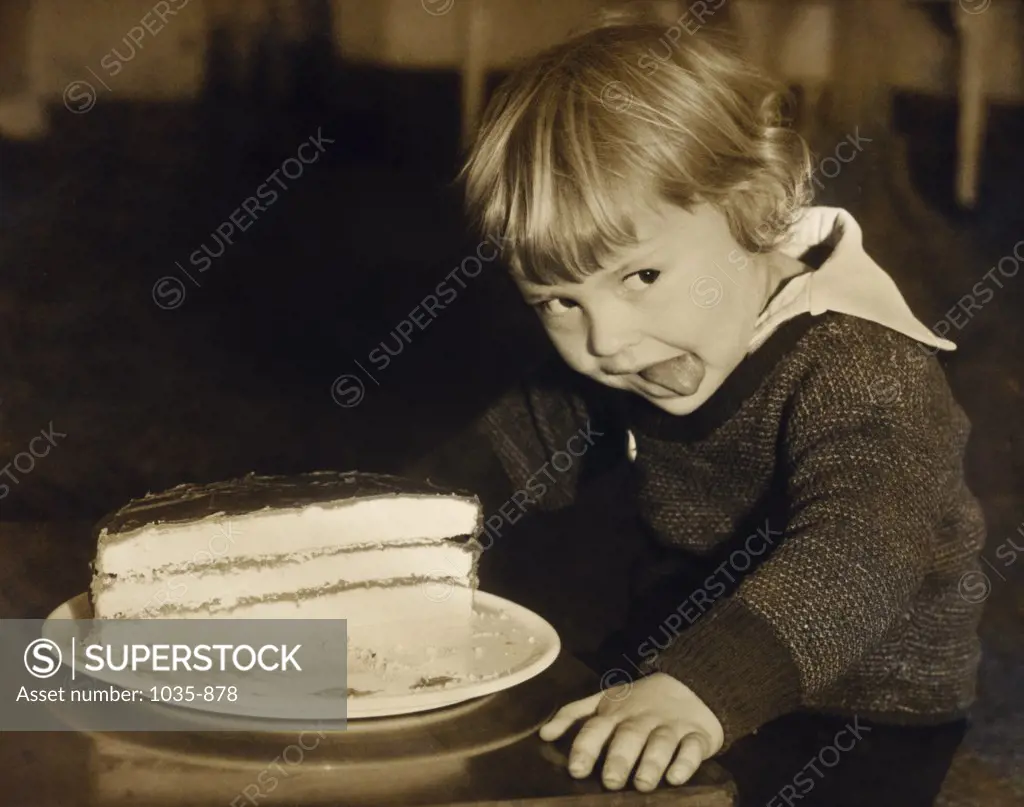 Close-up of a child sitting in front of a birthday cake