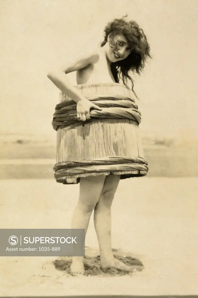 Portrait of a young woman covering her body with a barrel