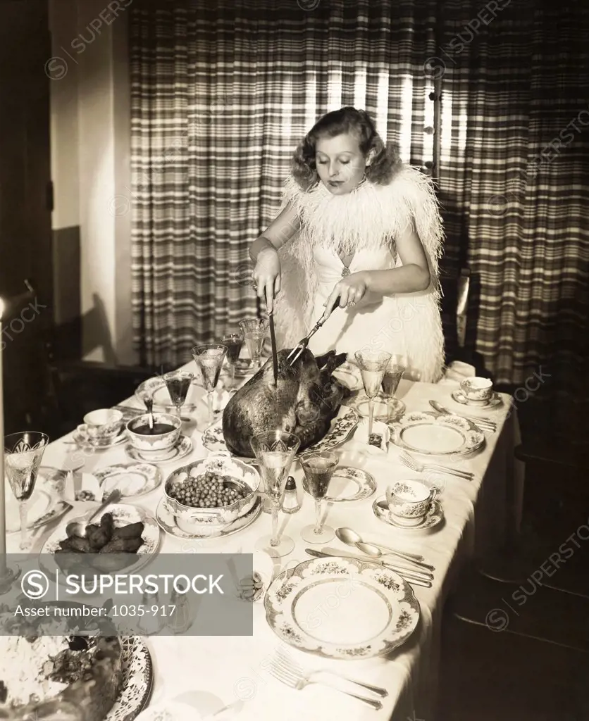 Actress Lilian Harvey (1907-1968) carving a turkey
