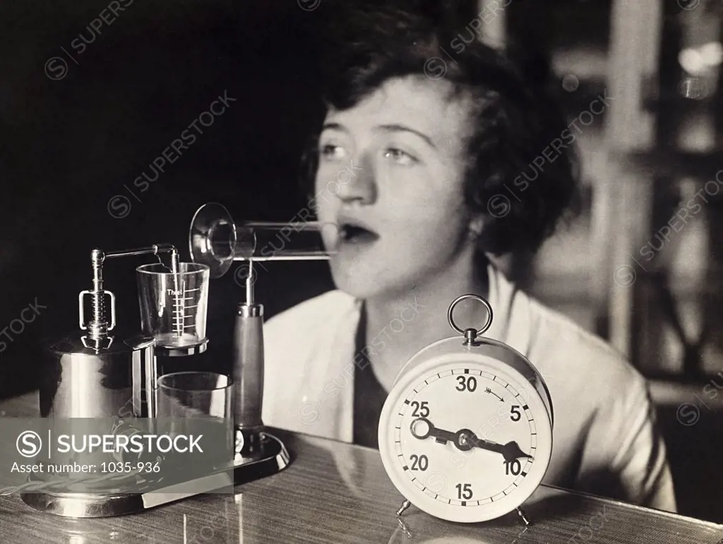 Mid adult woman inhaling medicine from an electric inhaling apparatus