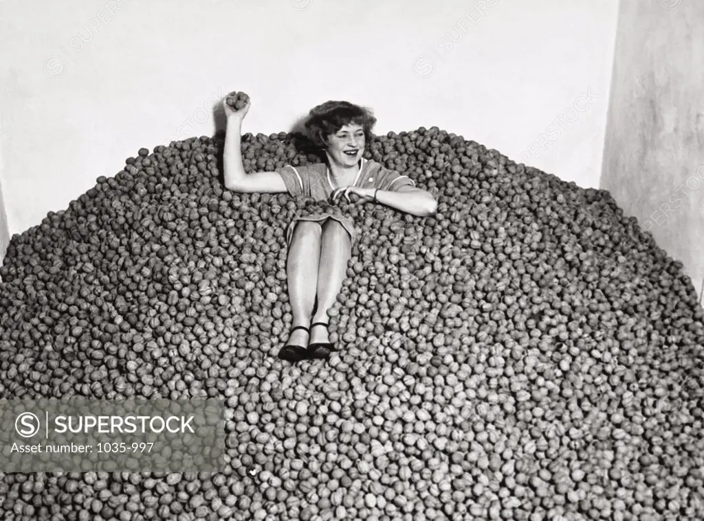 Mid adult woman in a heap of walnuts