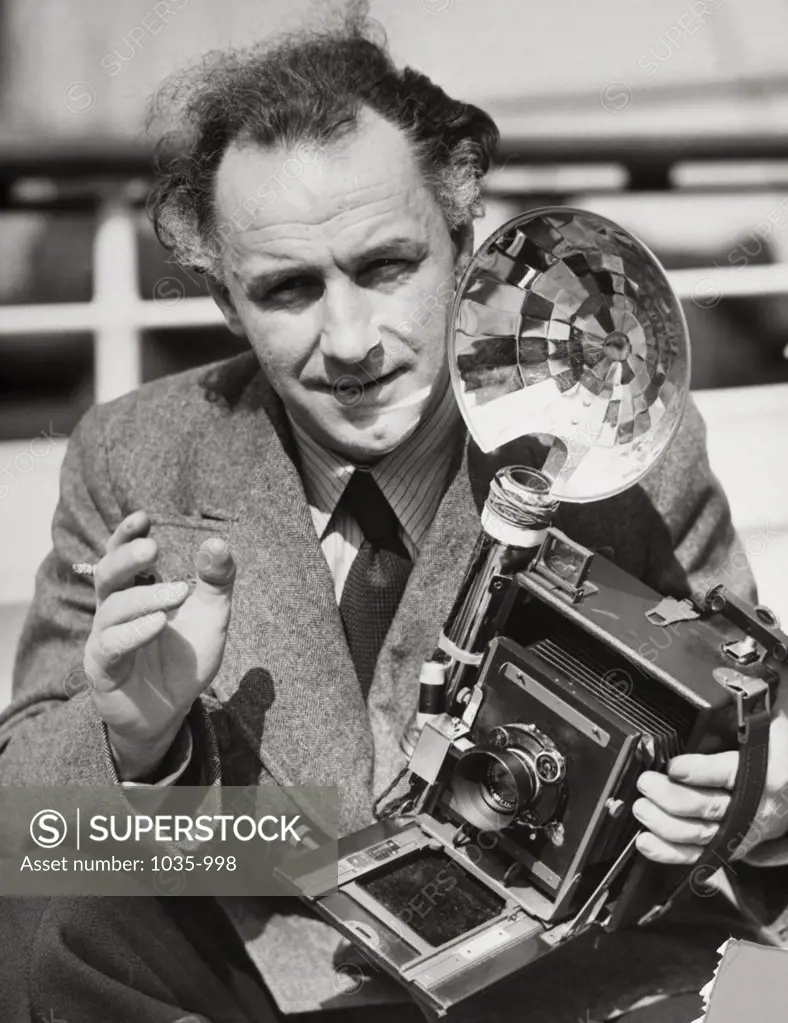 Portrait of a journalist holding a camera, 1937