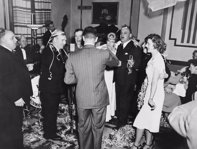 United States:   January 1, 1948 A group of people at a New Year's Eve party at the Hotel Stone singing and having much fun.
