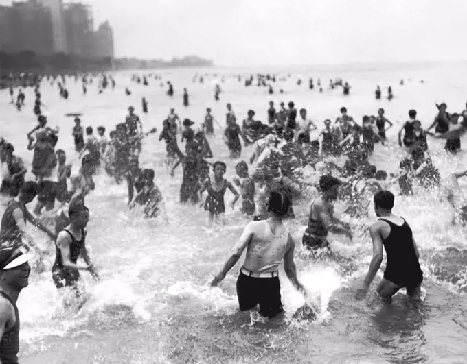 Chicago, Illinois:  July 3, 1928 A water fight on a hot day at the Oak Street Beach which is the most popular beach for the near north siders.