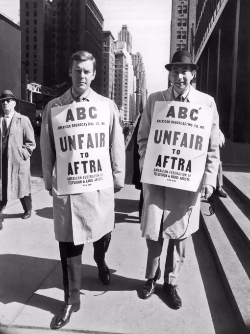 New York, New York:  March, 1967 ABC anchor man Peter Jennings, (L) and sports commentator Howard Cosell (R) picket outside ABC offices on the Avenue of the Americas in support of AFTRA, the American Federation of Television and Radio Artists.