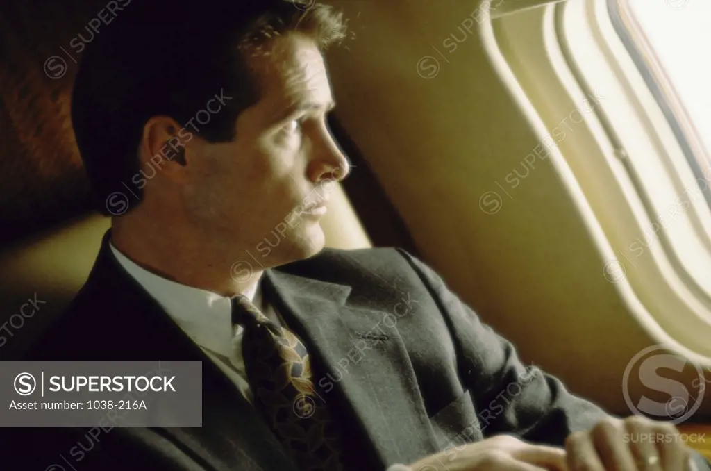 Businessman looking out of an airplane window