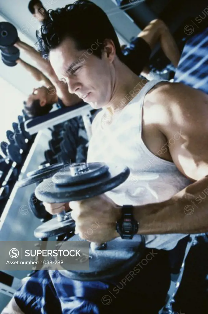 Young man exercising with dumbbells