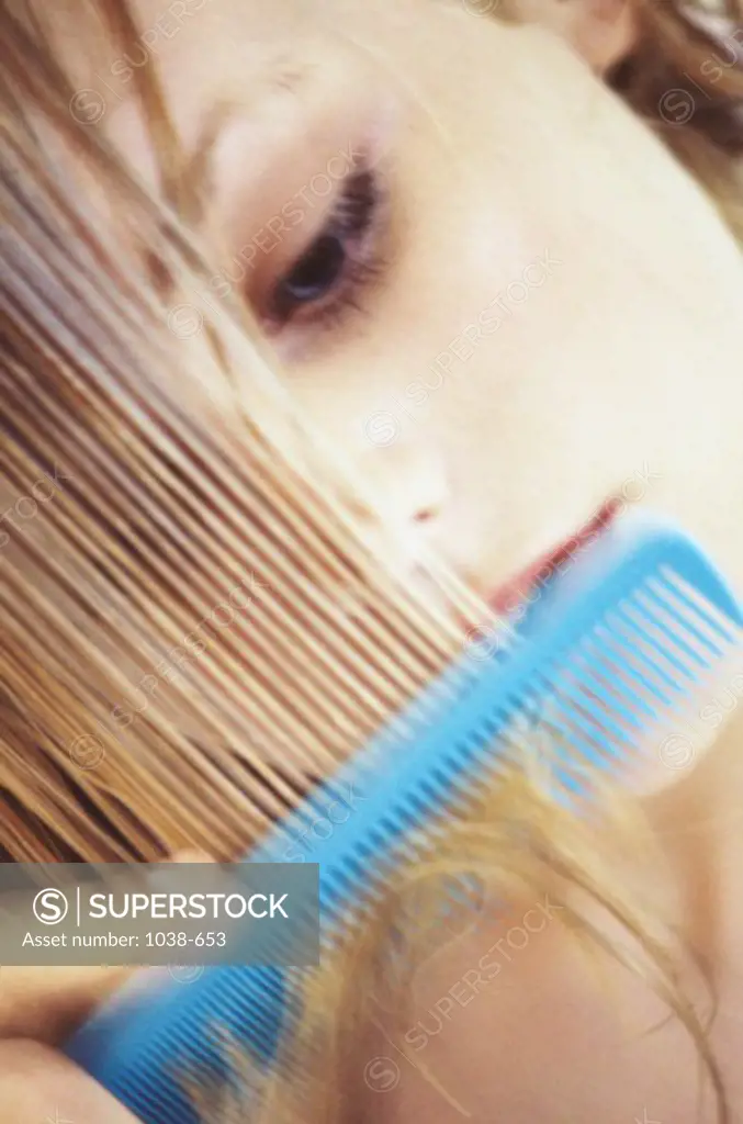 Close-up of a young woman combing her hair