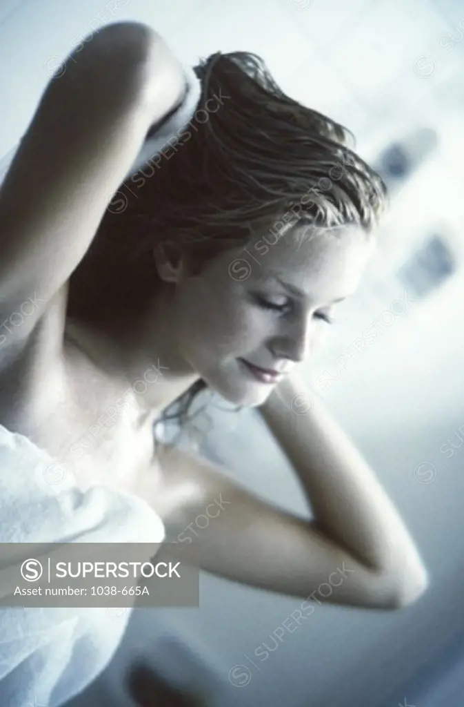 Young woman drying her hair with a towel
