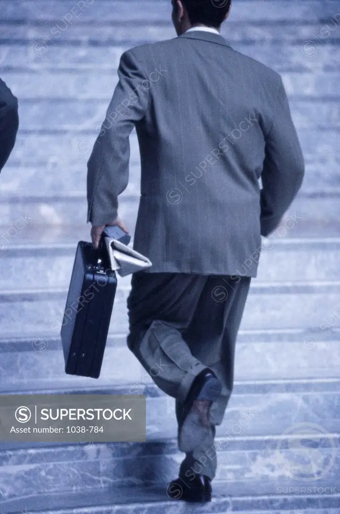 Rear view of a businessman walking up a staircase