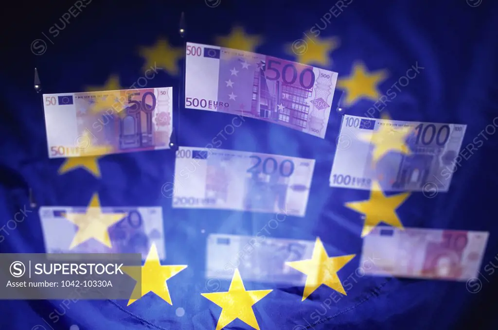 Close-up of euro banknotes with the European Union flag in the background
