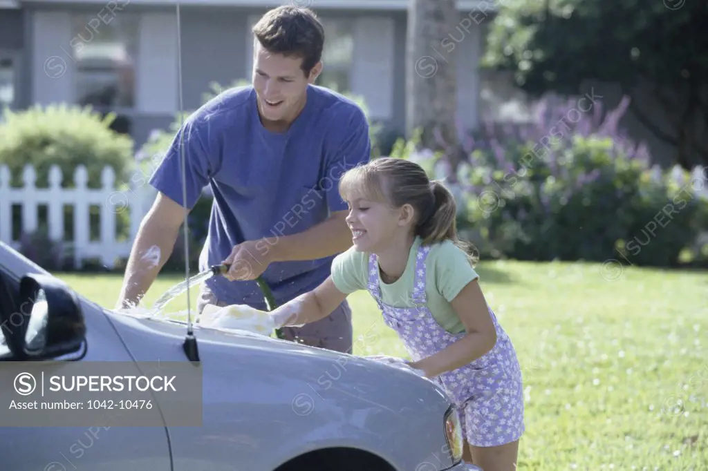 Father washing his car with his daughter