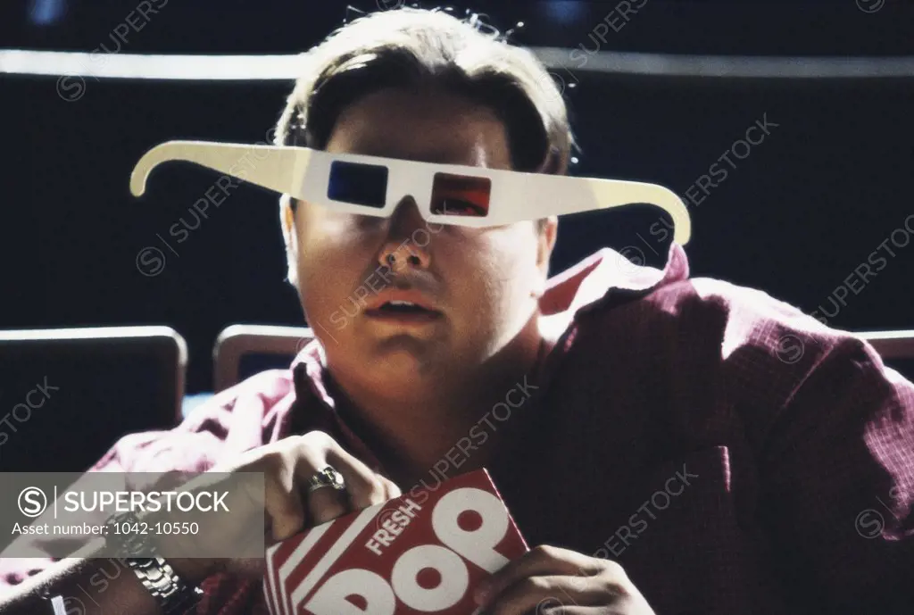 Portrait of a teenage boy wearing 3-D glasses in a theater