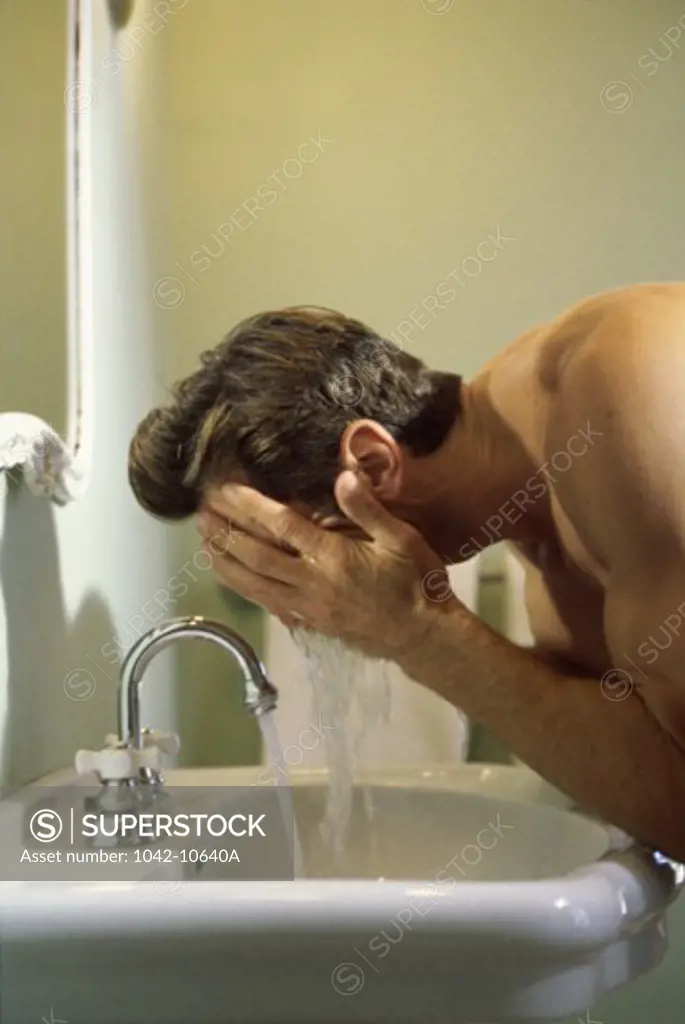 Young man washing his face