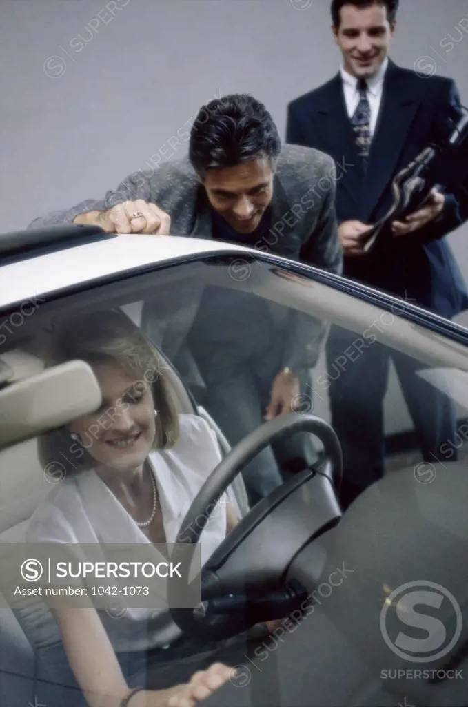 Mid adult woman sitting in a car in a showroom