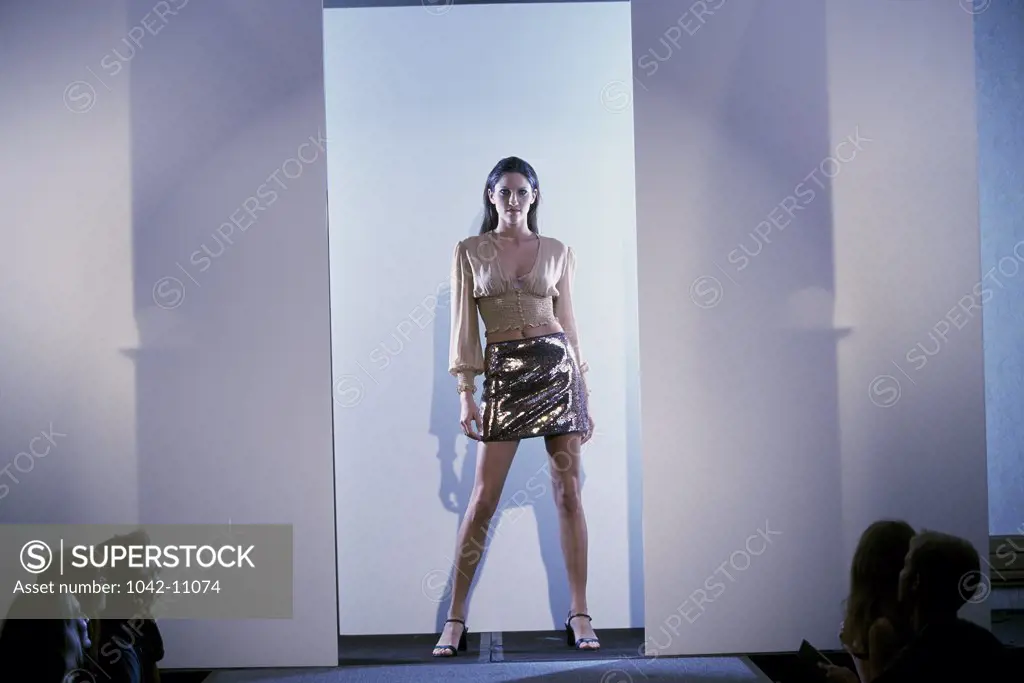 Female fashion model standing on a catwalk