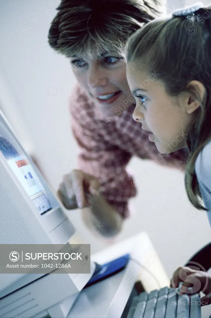 Side profile of a mother and her daughter using a computer
