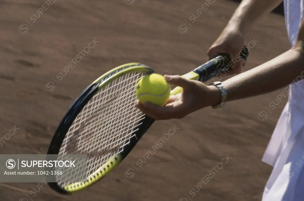 Person holding a tennis racket and a tennis ball