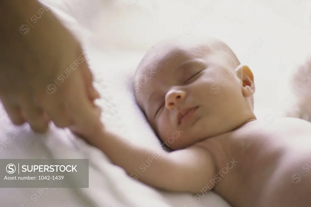 Person holding a baby boy's hand