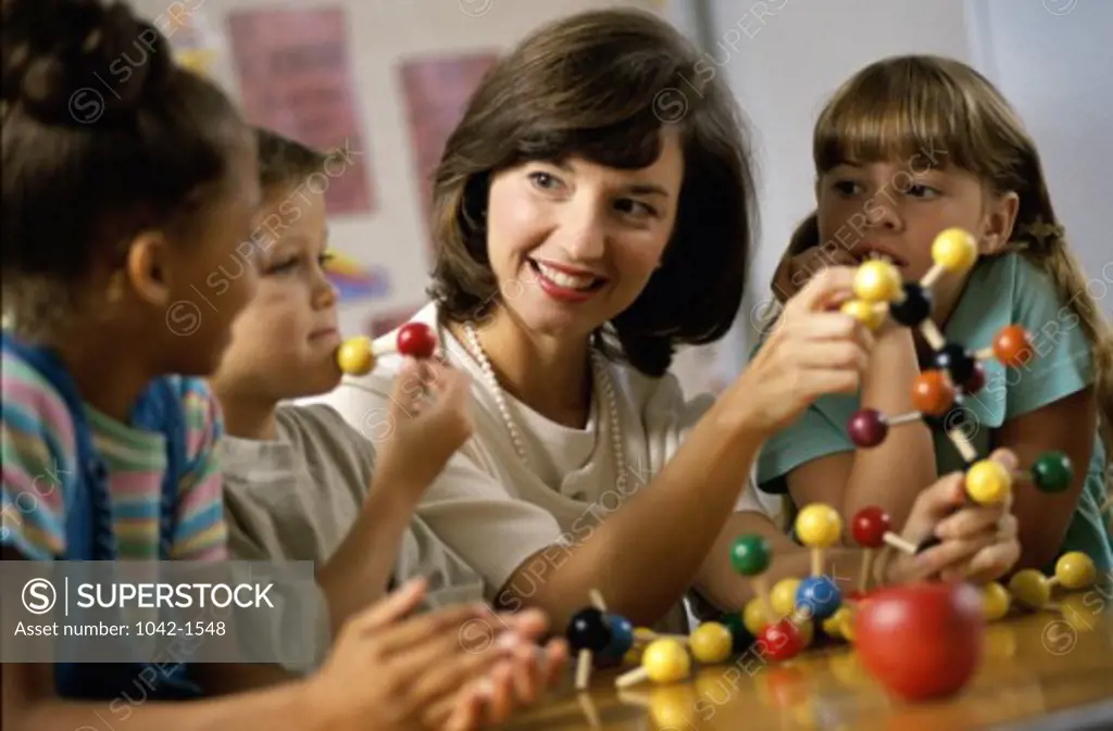 Teacher teaching her children about a molecular structure