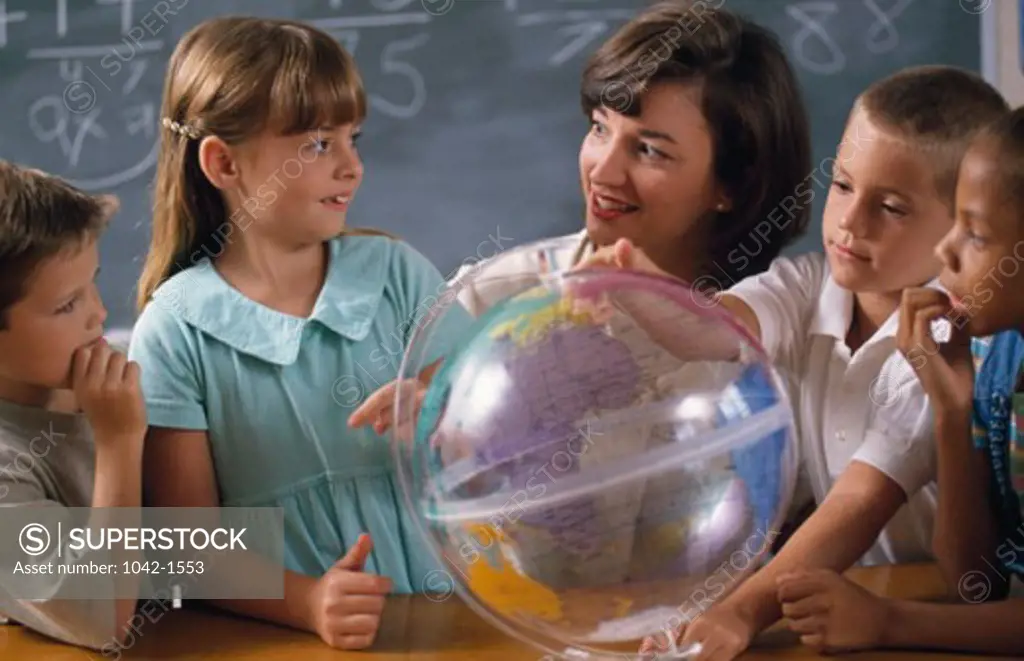 Teacher with her students studying the globe