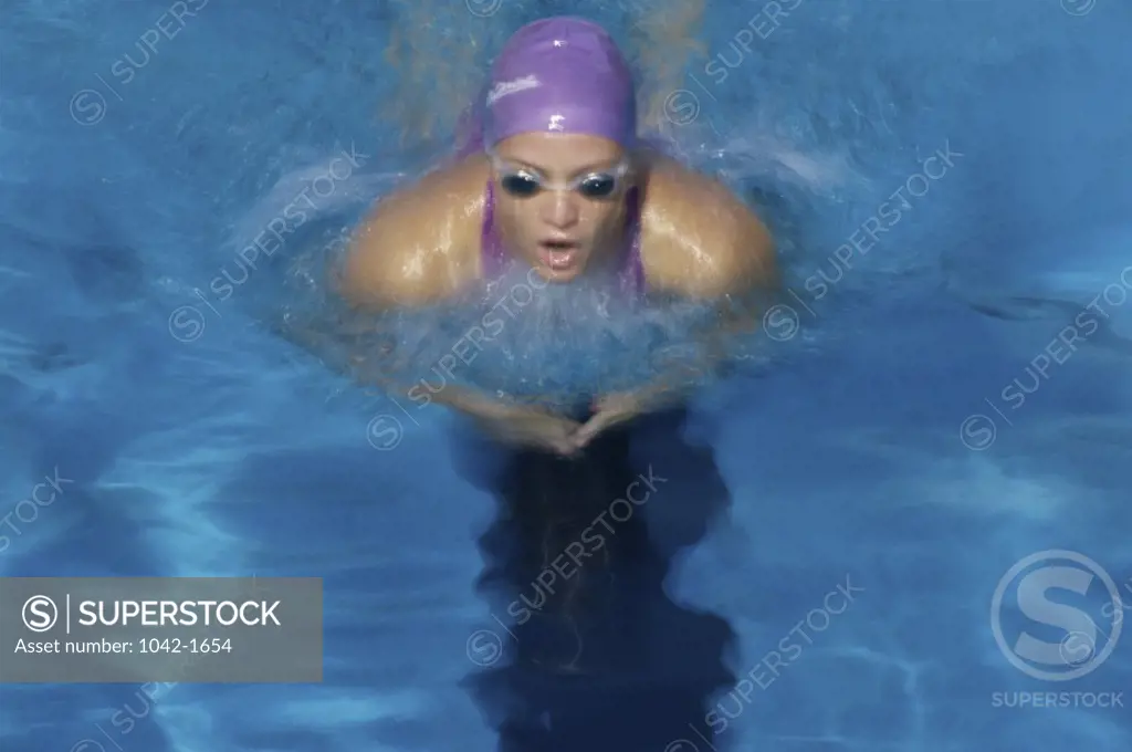 High angle view of a young woman swimming the breaststroke in a swimming pool