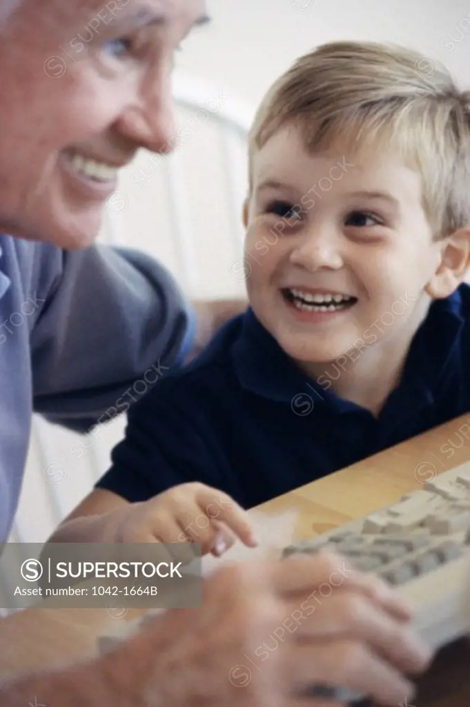 Grandfather and his grandson using a computer