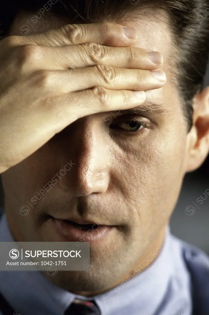 Close-up of a businessman holding his head