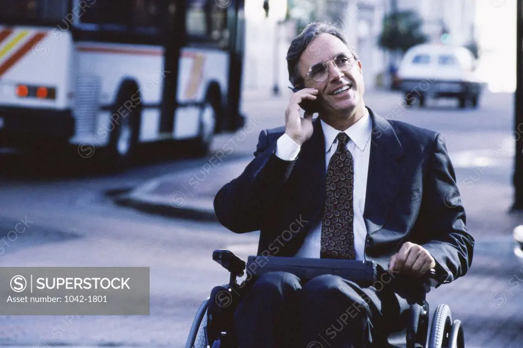 Close-up of a businessman in a wheelchair talking on a mobile phone