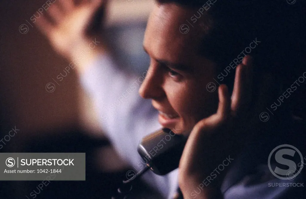 Side profile of a businessman talking on the telephone